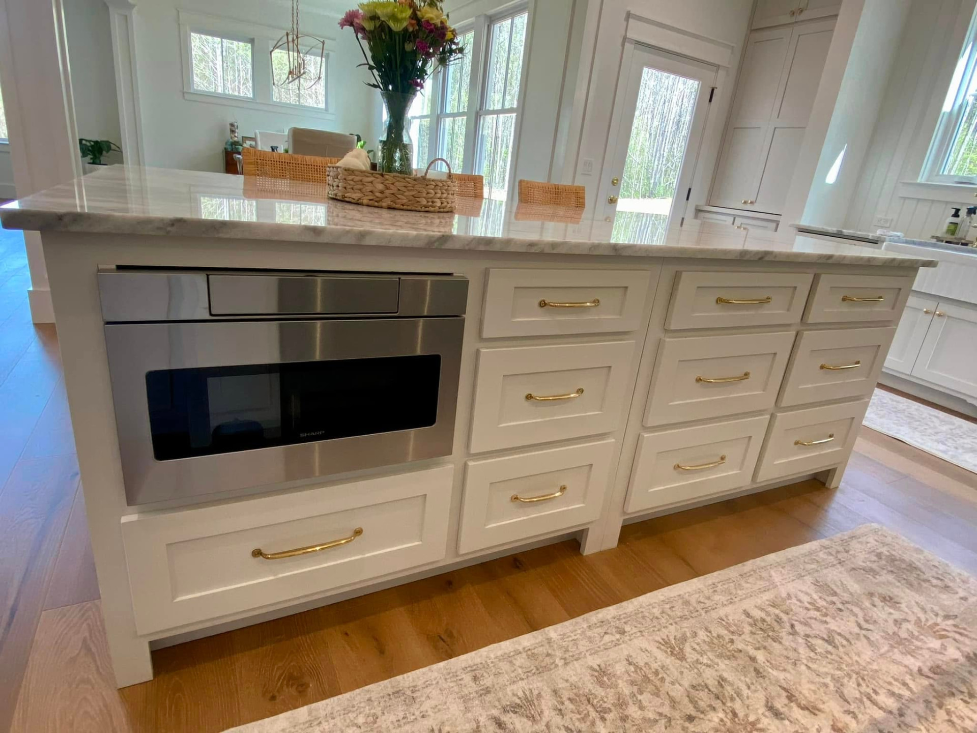 Long custom kitchen island with inset drawers and marble top