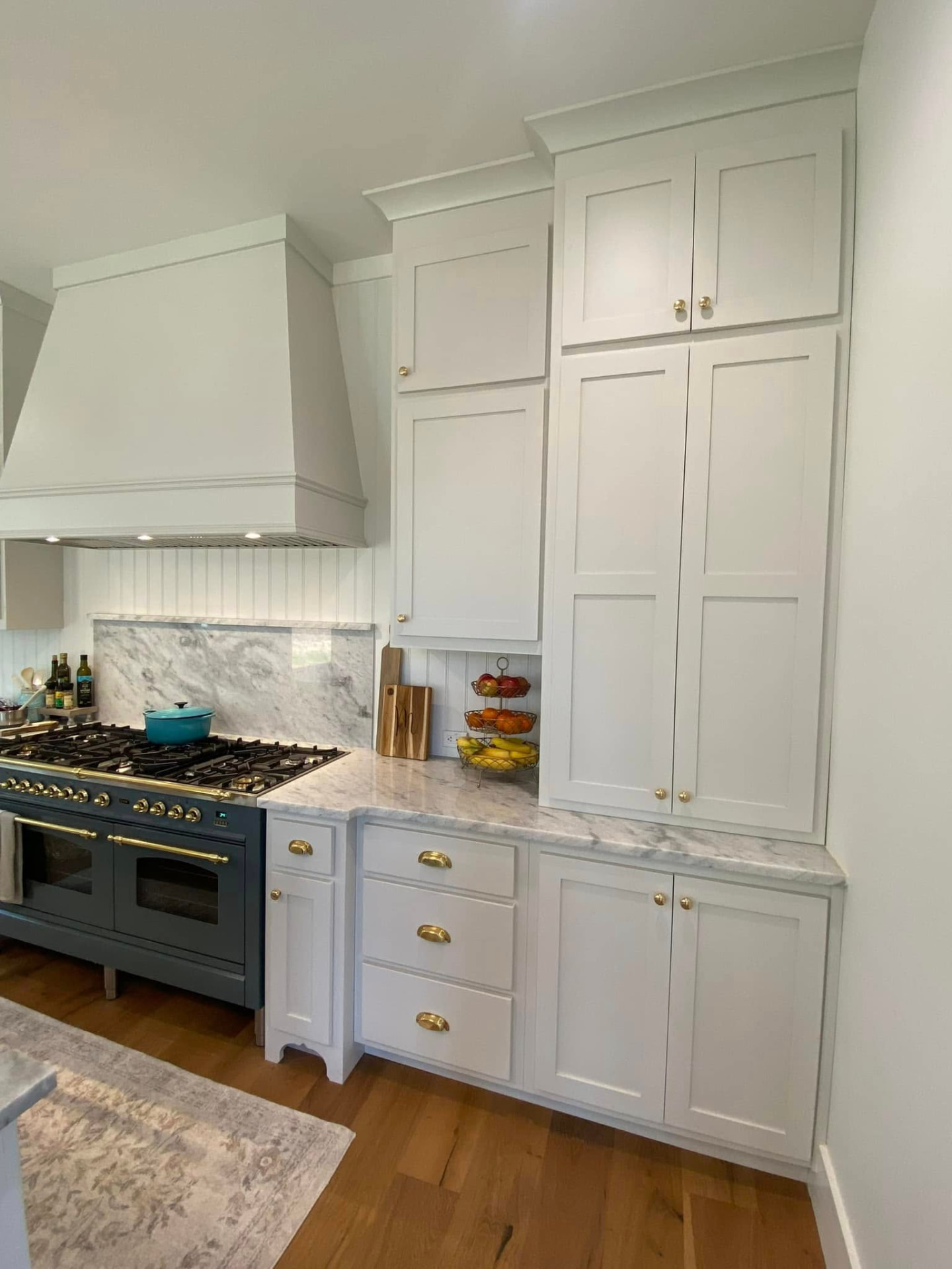 Custom cabinetry surrounding a range with a marble backsplash