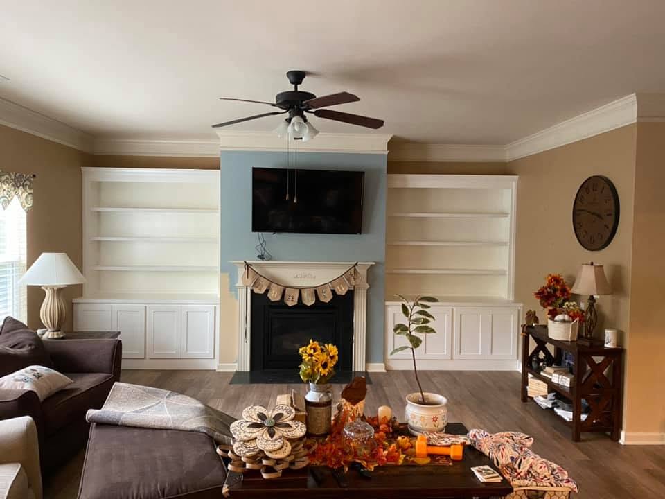 Custom white built-in bookshelves and cabinets flanking a living room fireplace